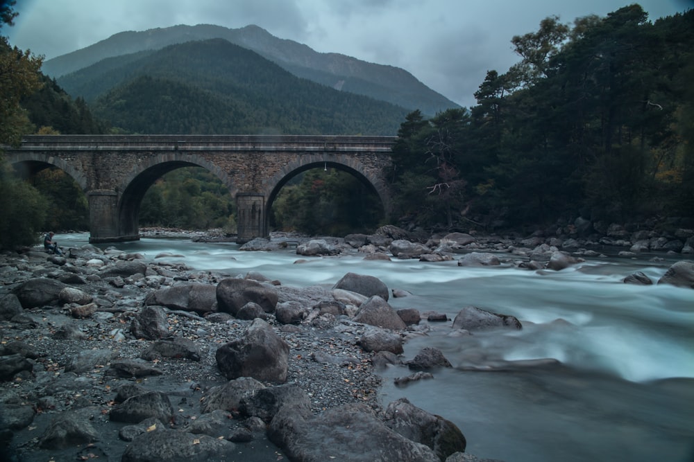 Pont en arc gris sur la rivière sous le ciel gris pendant la journée