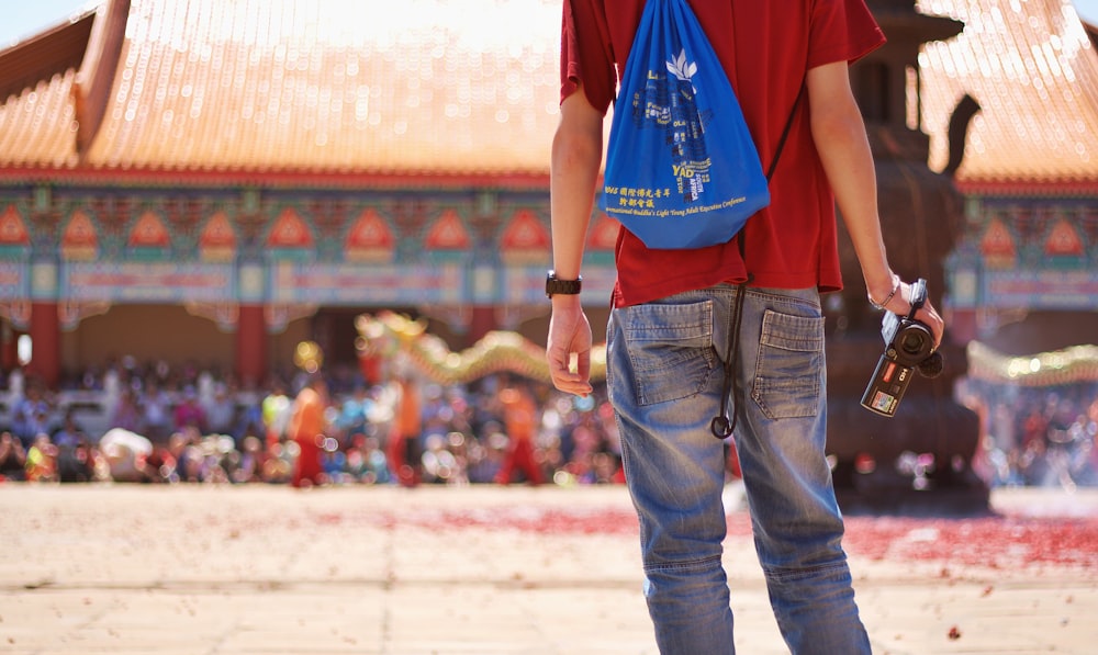 man wearing red shirt holding video camera