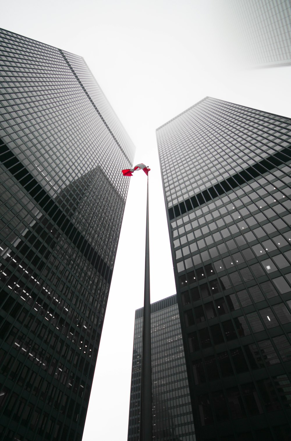 a red kite flying between two tall buildings