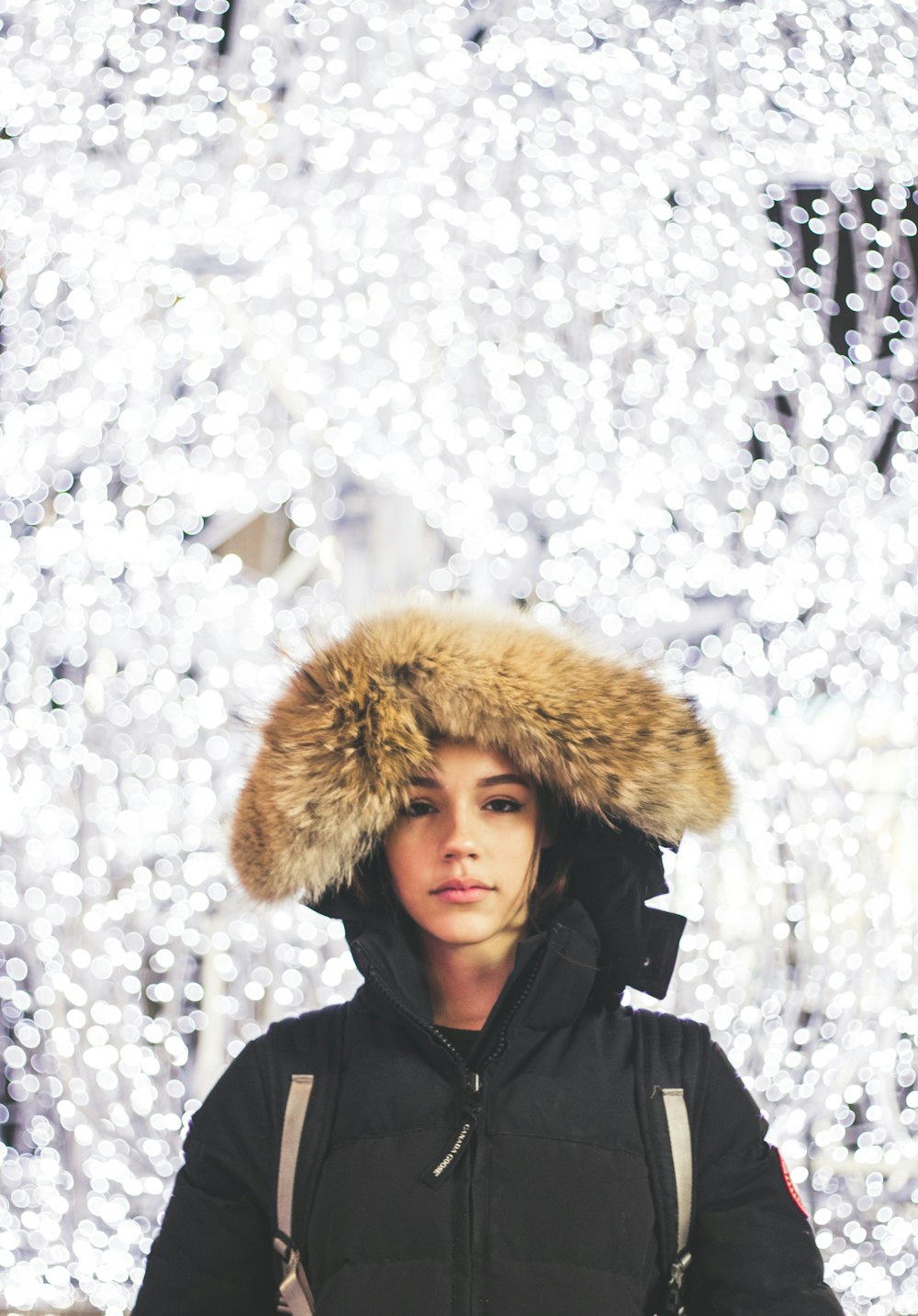 a woman standing in front of a christmas tree