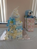 A delicate pink diaper cake decorated with soft ribbons and baby toys.