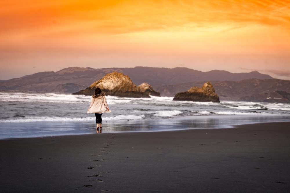 woman wearing on seashore during sunset