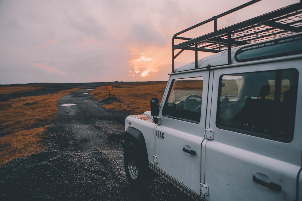 white wrangler with black steel roof rack on gray road