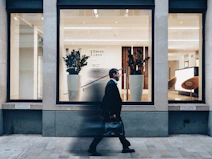 man in black suit jacket in walking gesture