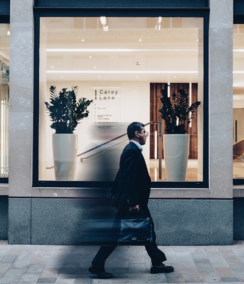 man in black suit jacket in walking gesture