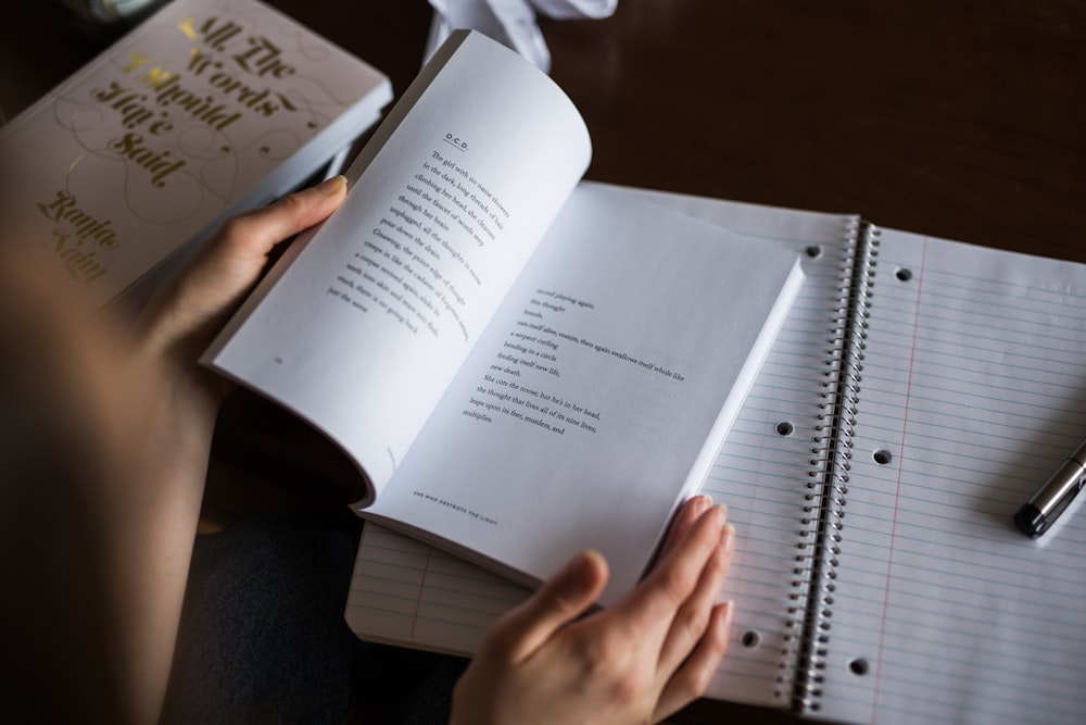 Person reading a book of poems and taking notes