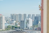 Wide shot of a painter working on a tall building facade.