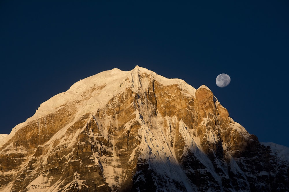 brown mountain under half moon