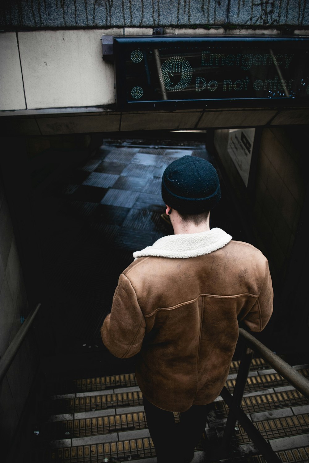 person in brown jacket walking on the stair
