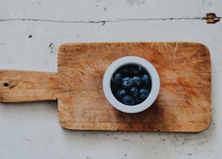 blueberries on white saucer on chopping board