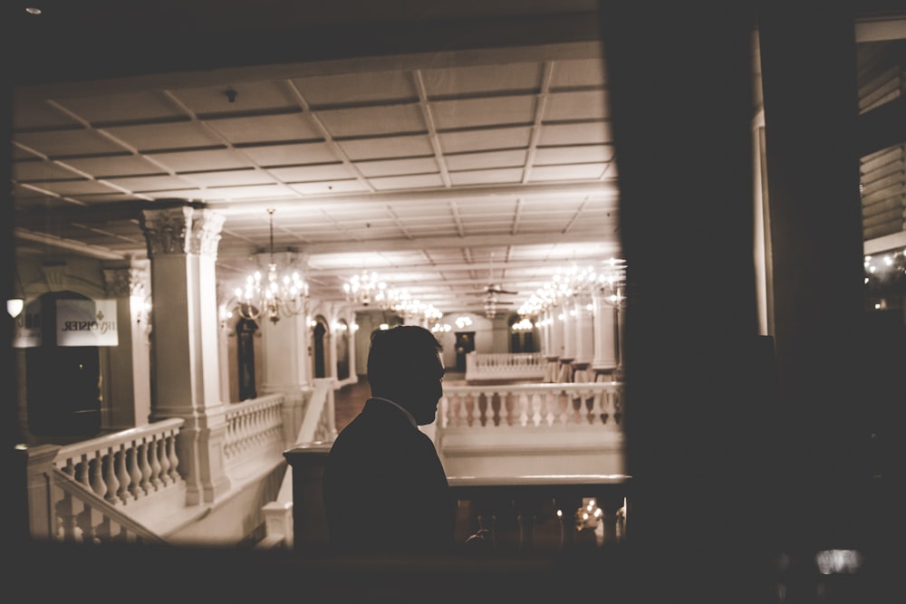 man standing inside higher floor of building near stairs