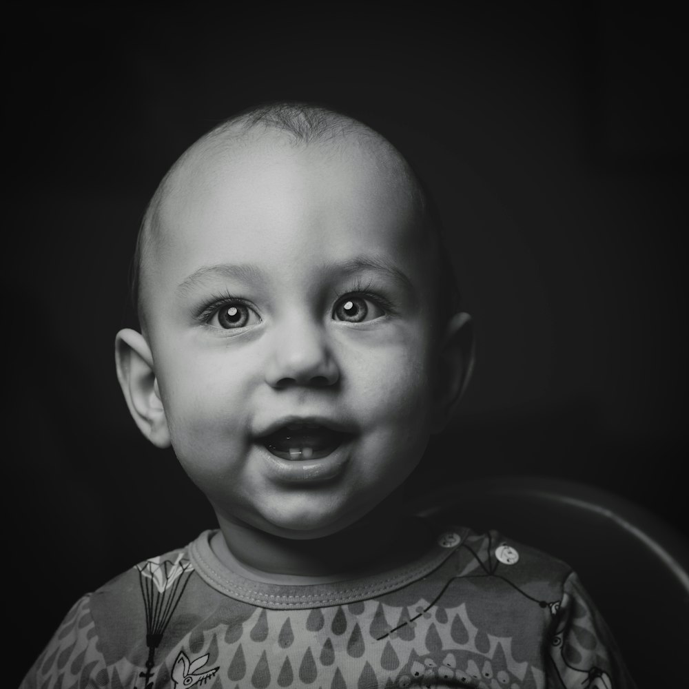 Foto en escala de grises de la parte superior de cuello redondo del bebé