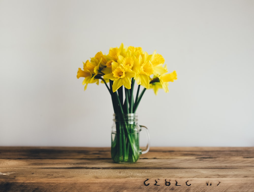 fiore petalo giallo su vaso di vetro trasparente