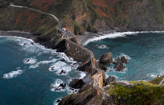 brown wall in the middle of two body of water in Gaztelugatxe Spain