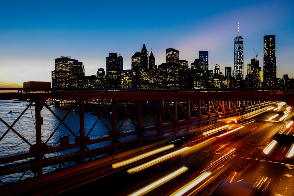 뉴욕시의 스카이라인을 배경으로 한 고속도로의 빛의 흔적을 장노출로 촬영한 사진