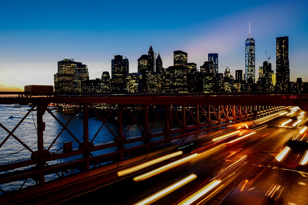 Uno scatto a lunga esposizione di scie luminose sull'autostrada con lo skyline di New York sullo sfondo