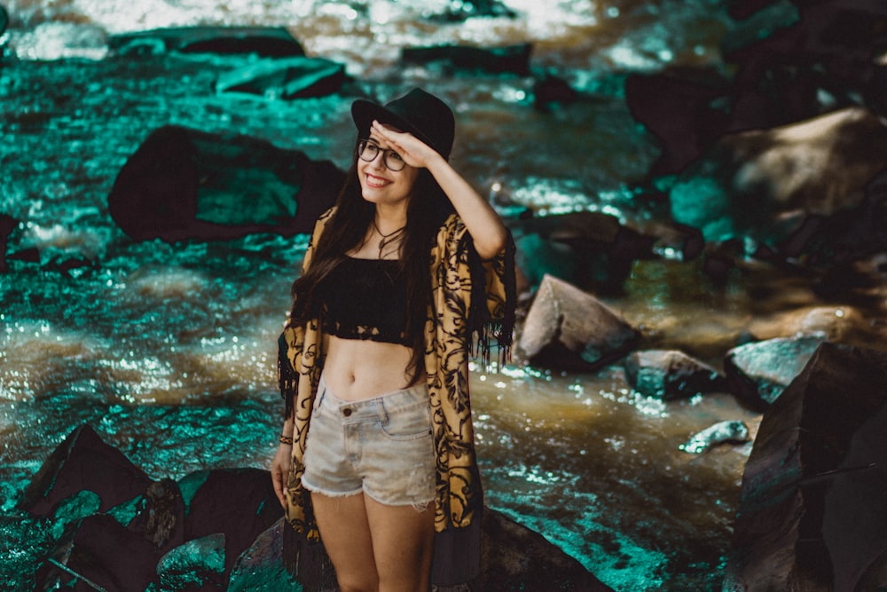 woman standing on rock near river