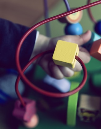 selective focus photo of baby playing activity cube