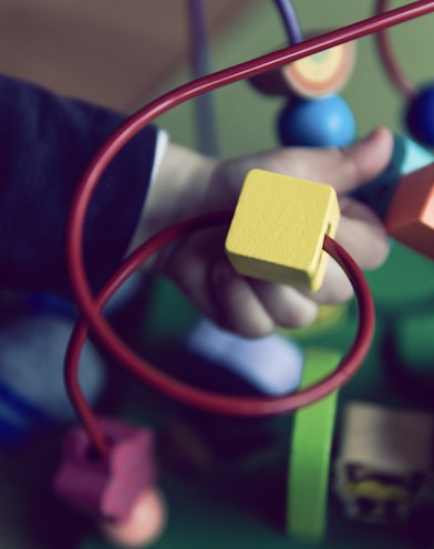 selective focus photo of baby playing activity cube