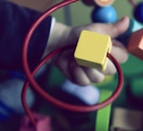 selective focus photo of baby playing activity cube