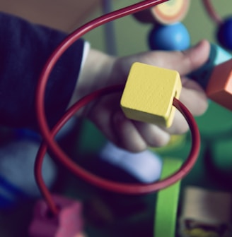 selective focus photo of baby playing activity cube