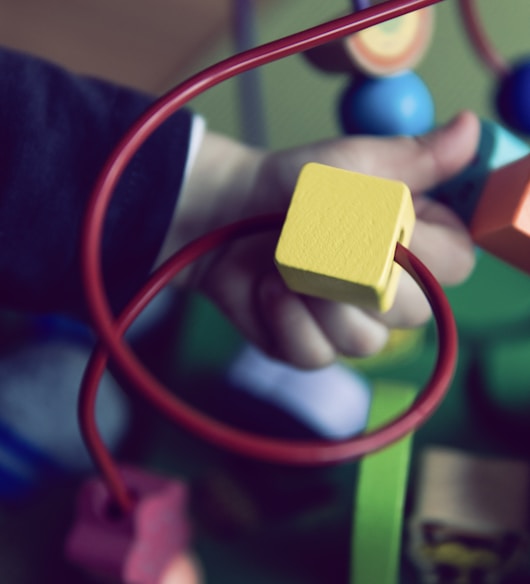 selective focus photo of baby playing activity cube