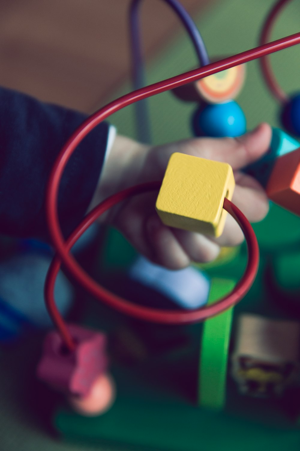 selective focus photo of baby playing activity cube
