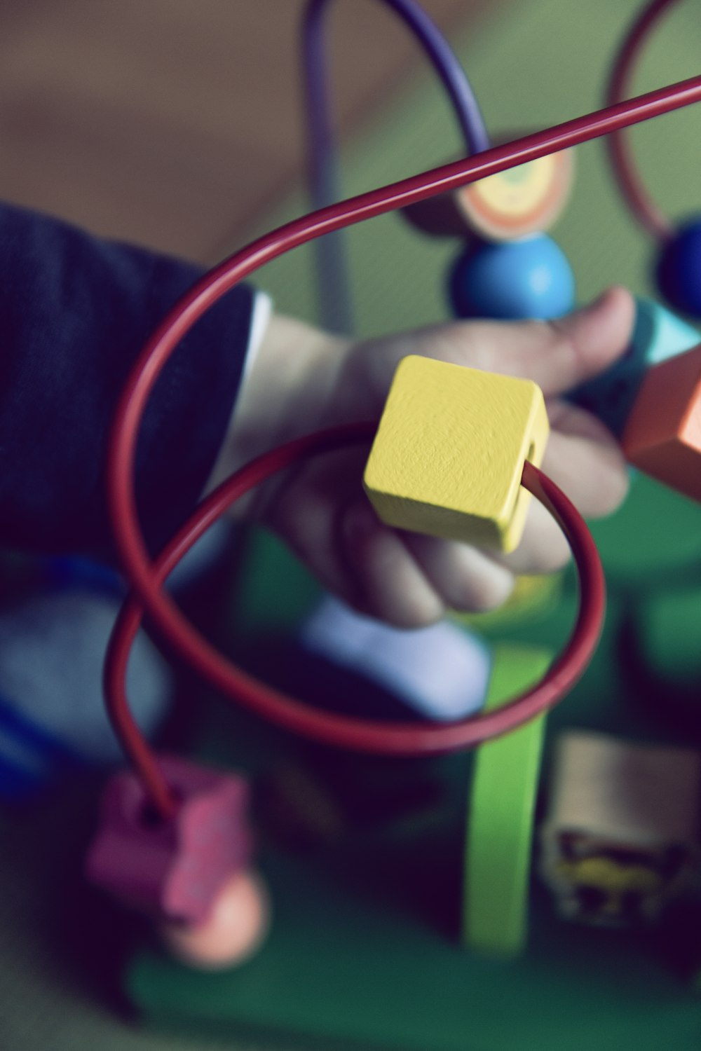 selective focus photo of baby playing activity cube