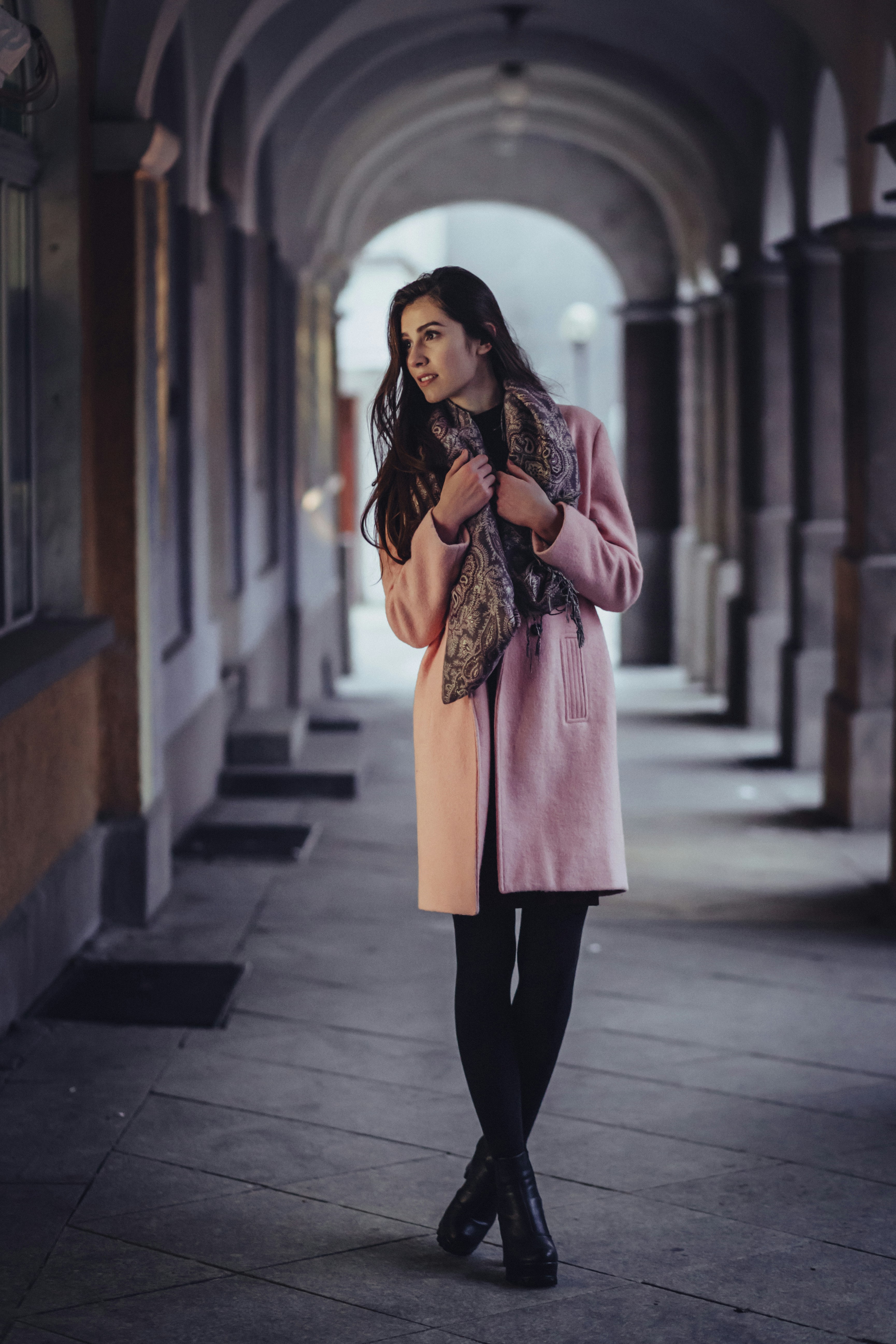 great photo recipe,how to photograph elegant woman by storefront; woman holding scarf with cross legs in between of gray concrete wall