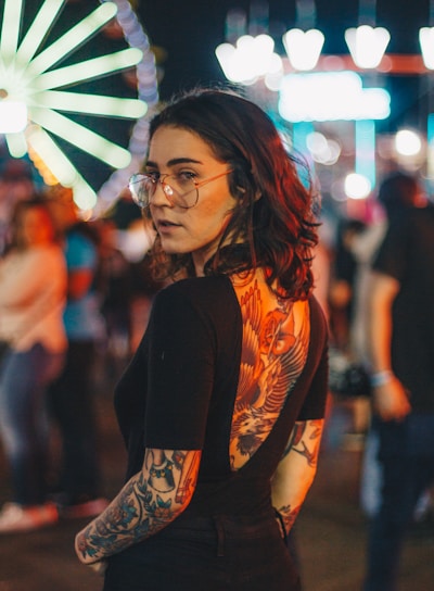 portrait photography of woman standing near Ferris Wheel