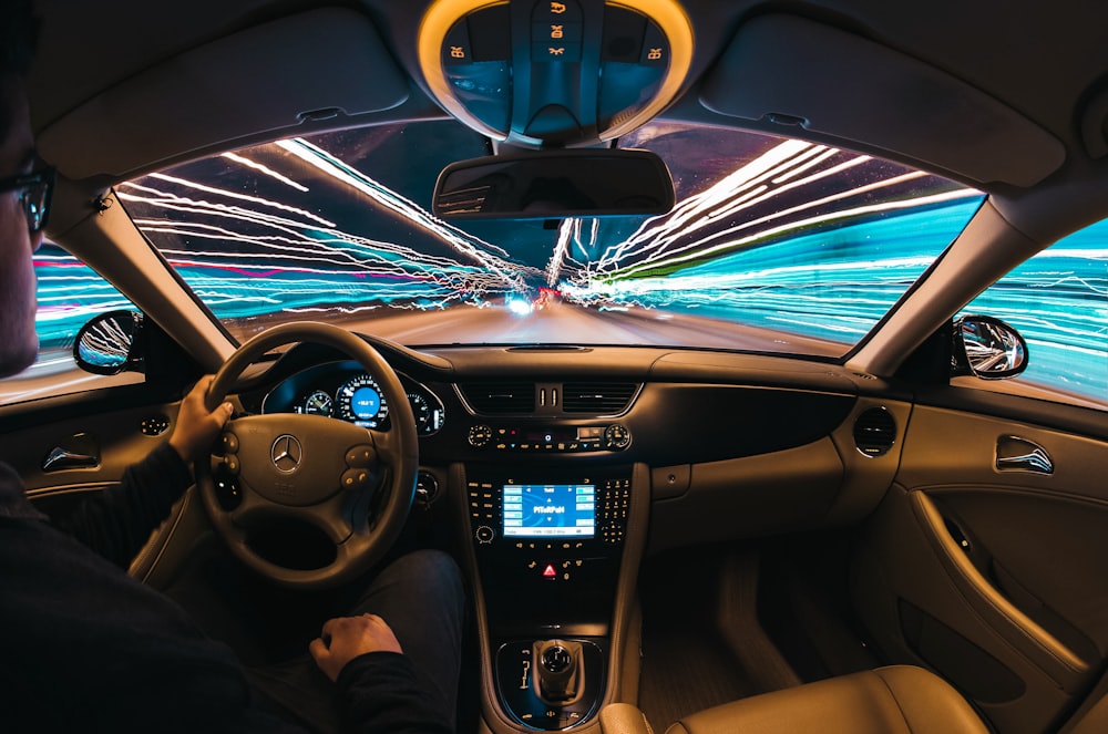 Photographie en accéléré d’un homme conduisant une voiture