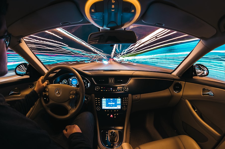 View from inside a car during a night drive; city light trails on the windshield