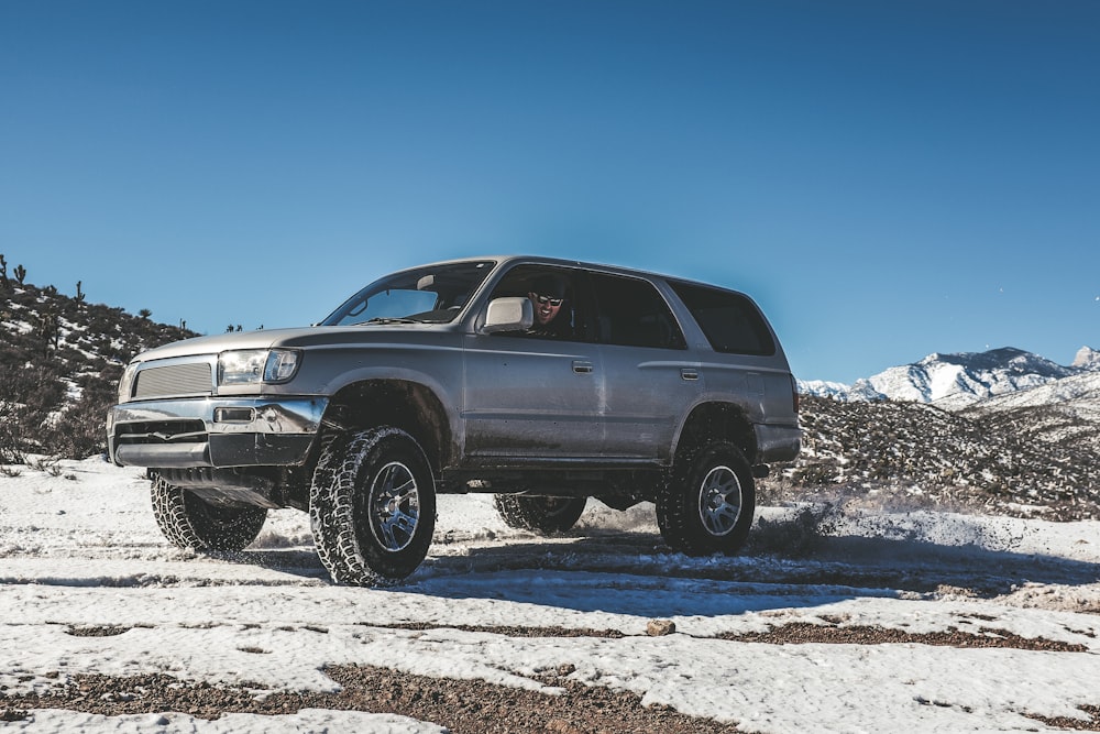 silver SUV on snow mountain