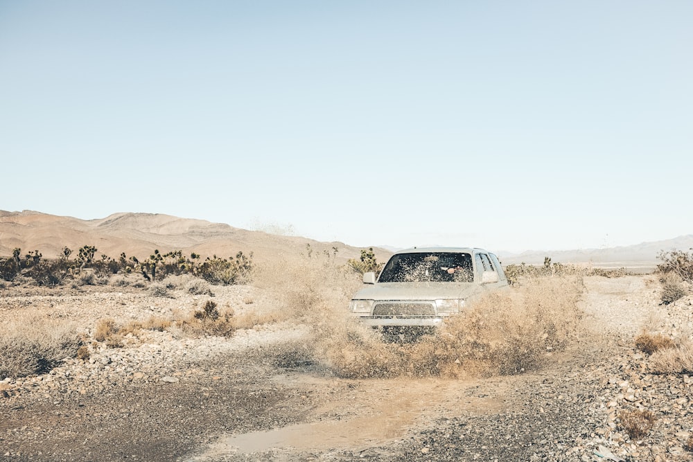 grey SUV on mud road