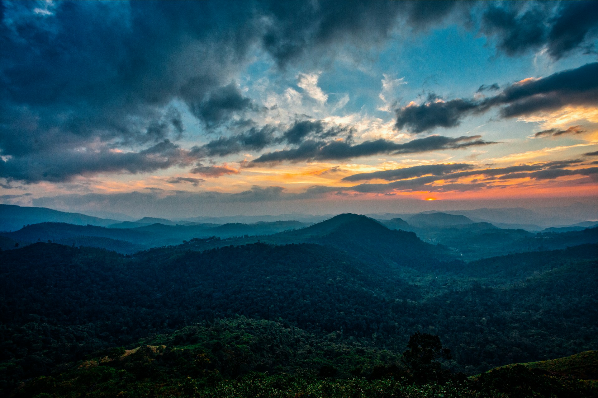 A stunning landscape showcasing a vibrant sunset over rolling hills.