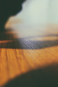 Close-up of warm light glowing softly over textured fabrics and natural wood surfaces.