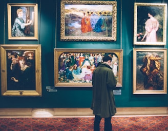 person standing near six paintings inside gallery
