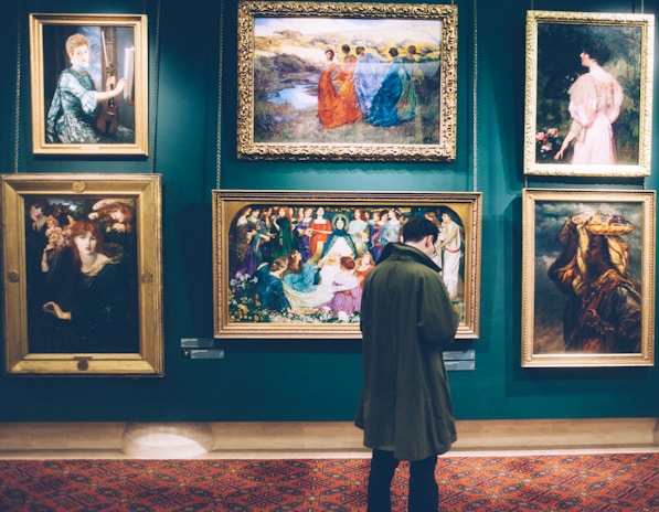 person standing near six paintings inside gallery