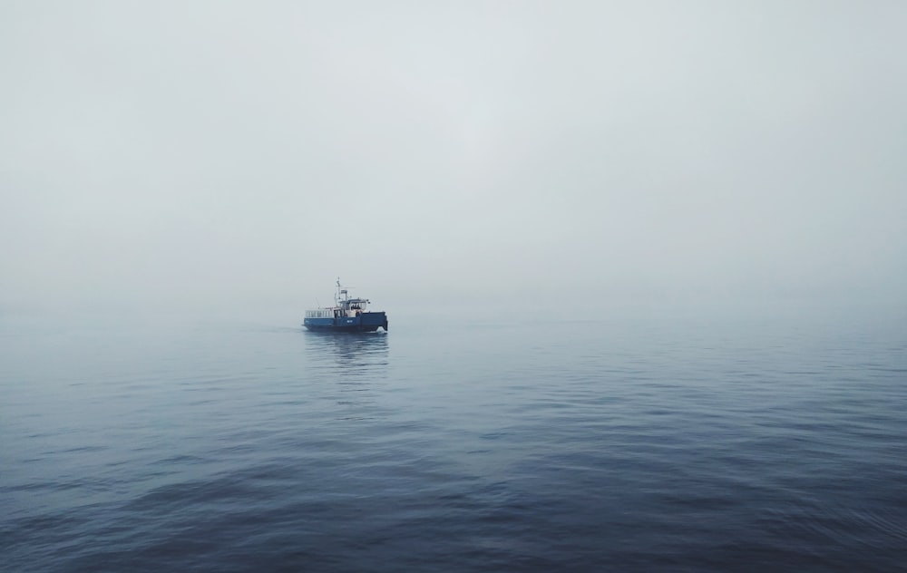 focus photo of black fishing boat on body of water