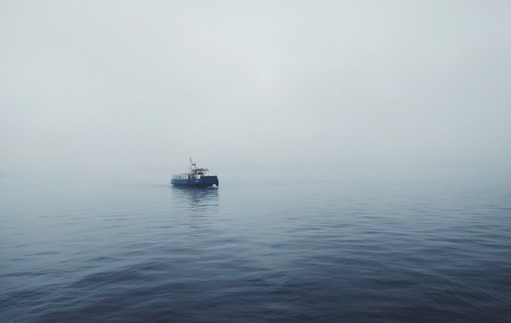Mise au point d’une photo d’un bateau de pêche noir sur un plan d’eau