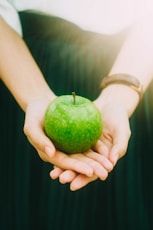 person holding green apple