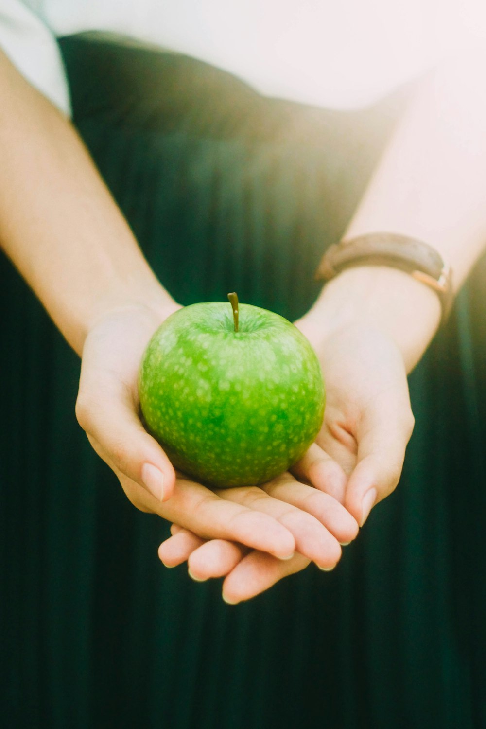 personne tenant une pomme verte