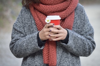 person holding red and white disposable cup