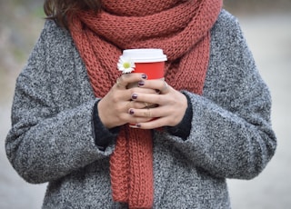 person holding red and white disposable cup