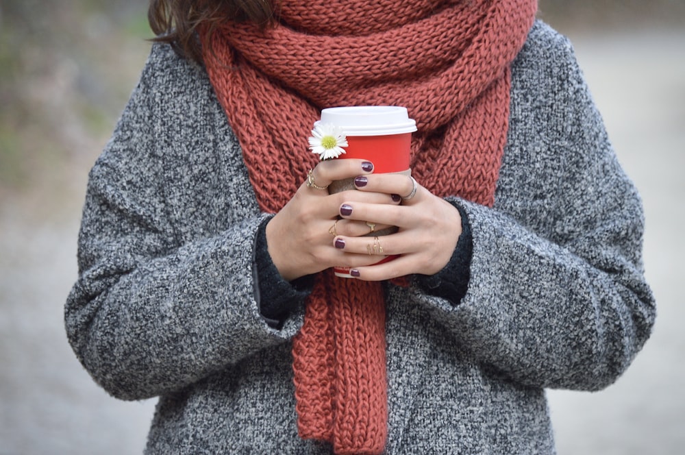 person holding red and white disposable cup