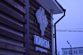 A sleek logo design displayed on a minimalist storefront sign with natural lighting.