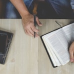 person holding bible with pen