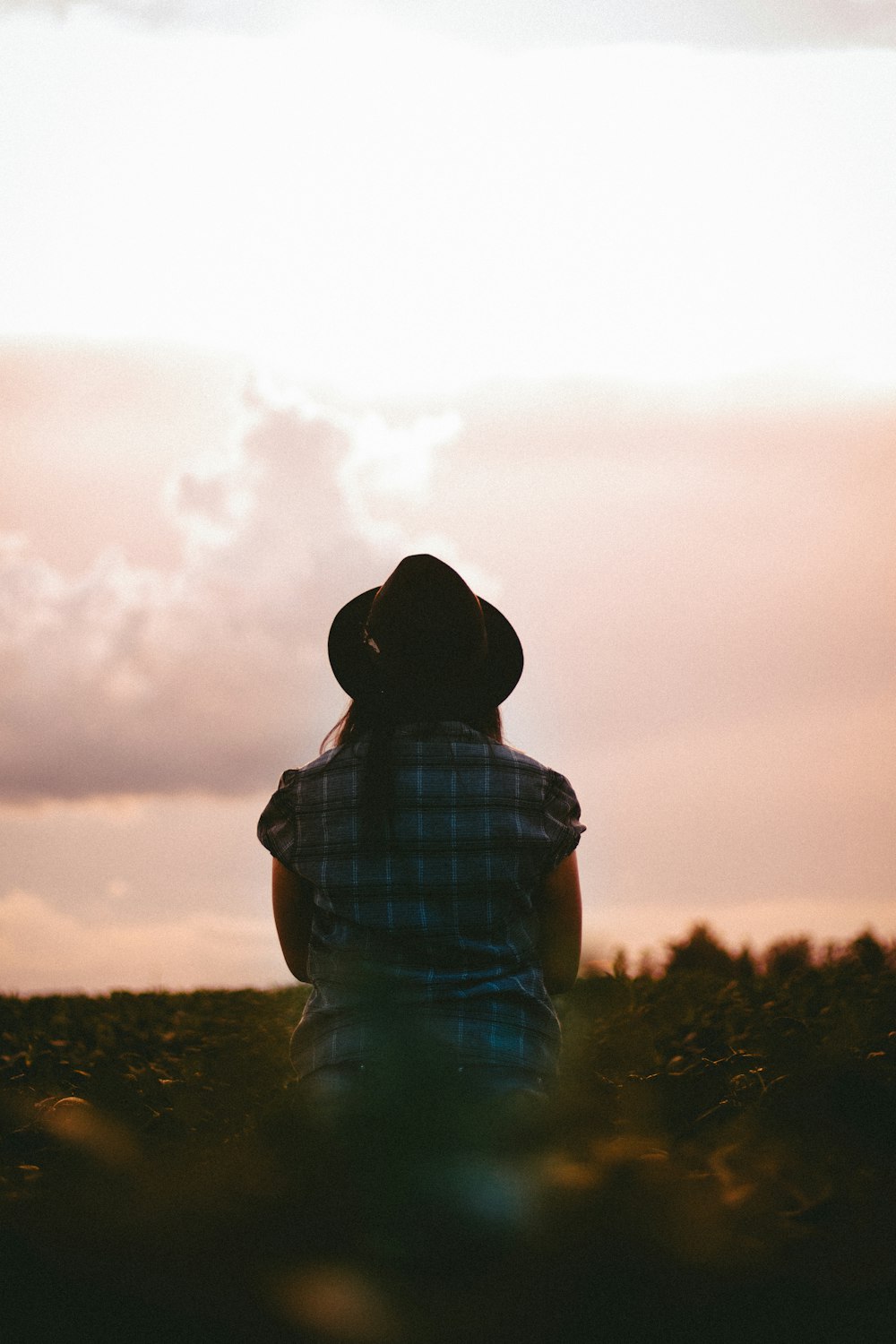 Mujer mirando al cielo mientras está de pie cerca de las plantas