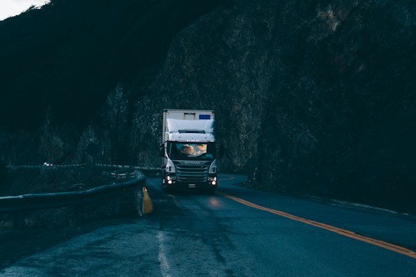 Tráiler circulando por carretera al anochecer, contexto del marketing digital para logística y transporte