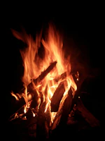 Warm flickering fire casting shadows on textured wooden table